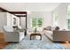 Bright living room with large windows, neutral furniture, and decorative rug at 406 Johns Woods Rd, Chapel Hill, NC 27516