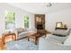 Cozy living room featuring a stone fireplace, hardwood floors, and comfortable seating at 406 Johns Woods Rd, Chapel Hill, NC 27516