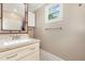 Powder room with granite countertop, white vanity, and decorative mirror, with a window for natural lighting at 411 E Green St, Franklinton, NC 27525