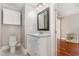 Bathroom features a white vanity, granite countertop, framed mirror, and convenient access to the bedroom at 411 E Green St, Franklinton, NC 27525