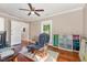 Spacious bedroom featuring hardwood floors, rocking chair, ceiling fan, and natural light from two windows at 411 E Green St, Franklinton, NC 27525