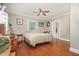 Bright bedroom features hardwood floors, a ceiling fan, and a queen-sized bed with neutral bedding and colorful wall decor at 411 E Green St, Franklinton, NC 27525
