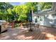 Outdoor deck with dining area and grill overlooks the spacious, green backyard and the house entrance at 411 E Green St, Franklinton, NC 27525