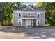 Charming two-story home featuring a metal roof and inviting front porch, surrounded by mature trees at 411 E Green St, Franklinton, NC 27525