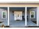 Inviting front porch with white columns, seating, and a charming entrance door at 411 E Green St, Franklinton, NC 27525