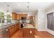 Bright kitchen with wooden cabinets, granite countertops, stainless steel appliances, and a center island for food preparation at 411 E Green St, Franklinton, NC 27525