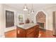 Large kitchen island with granite countertops and dark cabinets, complemented by a brick fireplace feature at 411 E Green St, Franklinton, NC 27525