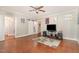 Open-concept living room featuring hardwood floors, a ceiling fan, and ample natural light at 411 E Green St, Franklinton, NC 27525