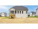 This is a view of the back of the home with a screen porch overlooking the yard at 422 Grading Stick Ct, Angier, NC 27501