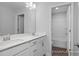 Bathroom featuring double sink vanity with white cabinets, a large mirror, and an adjoined toilet and shower room at 422 Grading Stick Ct, Angier, NC 27501