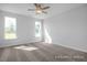 A well-lit bedroom showcases neutral carpet, ceiling fan and large windows providing ample natural light at 422 Grading Stick Ct, Angier, NC 27501