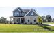 Charming two-story home featuring blue siding, brick accents, and a well-manicured lawn at 422 Grading Stick Ct, Angier, NC 27501