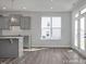 The open-concept kitchen boasts modern gray cabinets, stainless steel appliances, and light-filled windows at 422 Grading Stick Ct, Angier, NC 27501