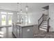 Open kitchen featuring gray cabinets, an island, and a view of the living room at 422 Grading Stick Ct, Angier, NC 27501