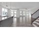 Open-concept living room featuring wood-look floors, a staircase, and access to a kitchen at 422 Grading Stick Ct, Angier, NC 27501