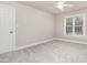 This is an empty bedroom with carpet flooring, a window, and neutral colored walls at 50 Pebble Creek Dr, Franklinton, NC 27525