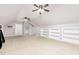 Large bonus room featuring carpeted flooring, dual ceiling fans, and custom built-in shelving at 50 Pebble Creek Dr, Franklinton, NC 27525