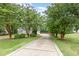 Long driveway lined with mature trees, leading to a home with professional landscaping and a private setting at 50 Pebble Creek Dr, Franklinton, NC 27525
