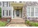 Welcoming front entrance with a detailed glass door, stone accents, and meticulously maintained landscaping at 50 Pebble Creek Dr, Franklinton, NC 27525