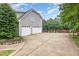 Three-car garage with ample parking space and additional space on the concrete pad next to the fence at 50 Pebble Creek Dr, Franklinton, NC 27525