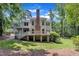 Back exterior showcasing the two-story home with a brick chimney, covered porch, and an expansive yard at 5121 Ten Point Trl, Wake Forest, NC 27587