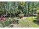 The backyard features a blend of manicured lawn and wooded area, with a small creek and bridge at 5121 Ten Point Trl, Wake Forest, NC 27587
