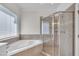 Bright bathroom featuring a soaking tub next to glass-walled walk in shower at 5121 Ten Point Trl, Wake Forest, NC 27587