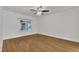 Bright bedroom with hardwood floors, ceiling fan and large window overlooking outdoor trees at 5121 Ten Point Trl, Wake Forest, NC 27587
