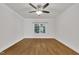Bright bedroom with hardwood floors, ceiling fan and a large window overlooking outdoor trees at 5121 Ten Point Trl, Wake Forest, NC 27587