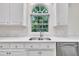 Kitchen detail featuring a double sink, stainless steel dishwasher, and arch window at 5121 Ten Point Trl, Wake Forest, NC 27587