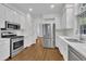 Well-lit kitchen with stainless steel appliances, a gas range, and white cabinetry at 5121 Ten Point Trl, Wake Forest, NC 27587