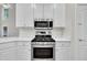 Kitchen detail showcasing stainless steel gas range, microwave, and white cabinetry at 5121 Ten Point Trl, Wake Forest, NC 27587