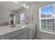 Well-lit bathroom featuring a double vanity with gray cabinets, quartz countertop, and a large mirror at 518 Toran Dr, Wake Forest, NC 27587