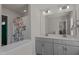 Bathroom featuring a double vanity with gray cabinets, quartz countertop, and a shower with a floral curtain at 518 Toran Dr, Wake Forest, NC 27587
