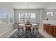 Elegant dining area with a round table, modern chandelier and natural light from large windows at 518 Toran Dr, Wake Forest, NC 27587