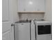 Well-lit laundry room featuring front loading washer and dryer with white cabinets for ample storage at 518 Toran Dr, Wake Forest, NC 27587