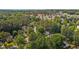 Aerial view of a neighborhood with lush green trees and houses, with a cityscape visible in the distance at 5301 Northpines Dr, Raleigh, NC 27610