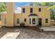 Exterior view of the yellow house with a black door and several windows overlooking the backyard at 5301 Northpines Dr, Raleigh, NC 27610