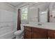 Bright bathroom featuring a bathtub with shower, toilet, vanity with sink, and a large mirror at 5301 Northpines Dr, Raleigh, NC 27610