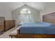 Bedroom with a vaulted ceiling, a large window, and a wooden bed frame at 5301 Northpines Dr, Raleigh, NC 27610