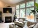 Bright living room with a fireplace, large windows, and a comfortable seating arrangement at 5708 Big Sandy Dr, Raleigh, NC 27616