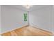 Bedroom features natural hardwood flooring, window and a modern ceiling light fixture at 702 Sanderson Dr, Durham, NC 27704