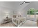 Sunlit bedroom features vaulted ceilings, a ceiling fan and a large window overlooking greenery at 702 Sanderson Dr, Durham, NC 27704