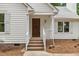 Charming front entrance with brick steps, detailed wood door, white railing, and classic white siding at 702 Sanderson Dr, Durham, NC 27704