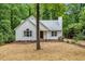 Charming home boasts brown straw lawn, white siding, brick foundation, mature trees, and professionally landscaped front yard at 702 Sanderson Dr, Durham, NC 27704