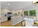 Kitchen with white cabinetry, stainless appliances, stone countertops, and sliding doors to deck at 702 Sanderson Dr, Durham, NC 27704