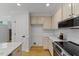 Kitchen with stone countertops, stainless steel appliances, white backsplash, and access to laundry at 702 Sanderson Dr, Durham, NC 27704