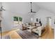 Bright living room features vaulted ceilings, hardwood floors, stylish decor, and view into dining room at 702 Sanderson Dr, Durham, NC 27704