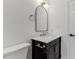 Elegant bathroom vanity with marble countertop, gold hardware, and arched mirror at 702 Sanderson Dr, Durham, NC 27704