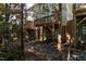 View of townhome backyard features multiple decks and levels, with trees and rock landscaping at 7244 Galon Glen Rd, Raleigh, NC 27613